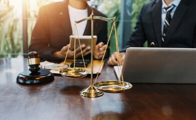 Justice and law concept.Male judge in a courtroom with the gavel, working with, computer and docking keyboard, eyeglasses, on table in morning light