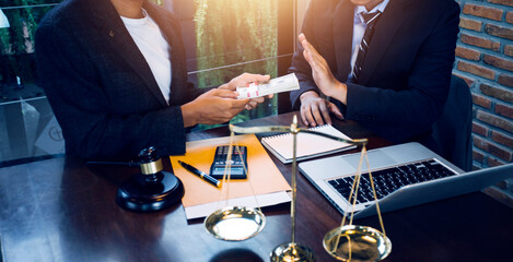 Justice and law concept.Male judge in a courtroom with the gavel, working with, computer and docking keyboard, eyeglasses, on table in morning light