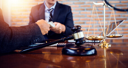 Justice and law concept.Male judge in a courtroom with the gavel, working with, computer and docking keyboard, eyeglasses, on table in morning light