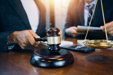 Justice and law concept.Male judge in a courtroom with the gavel, working with, computer and...