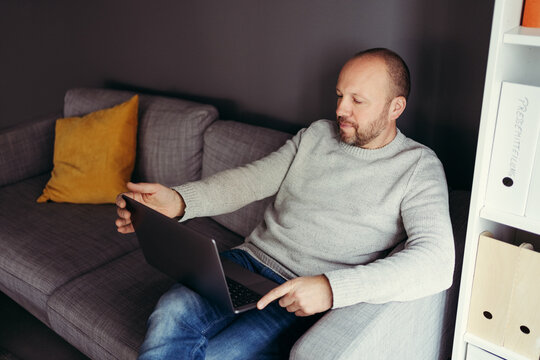 man sitting on the sofa with his laptop