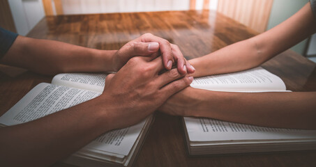 Husband and wife join hands and pray together on table, hope, faith, christianity, religion concept.