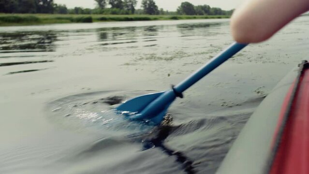 Close-up of a rower on a boat rowing with an oar.