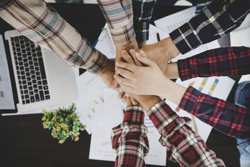 young business people putting their hands together