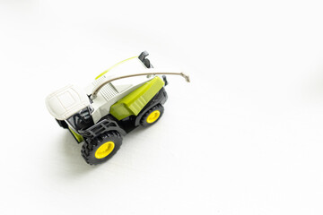 Small artificial tractor childrens' toy harvester.