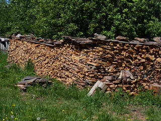 Woodpile lies in a heap, chopped for burning in a furnace. Finely chopped and stacked firewood, background. Laid dry firewood, texture, background. Firewood wall, dry chopped firewood background.