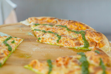 italian vegetarian focaccia with pesto on a wooen plate. Pizza with cheese
