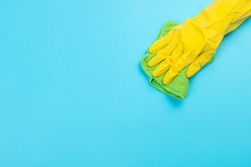 worker's hand in yellow rubber protective glove with micro fiber green sponge or washcloth. A maid or housewife takes care of the house. general or regular cleaning. 