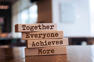 Wooden blocks with the word Together, Everyone, Achieves, More. Teamwork and team concept....