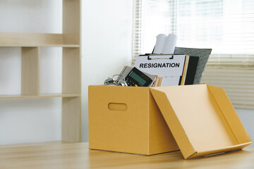 Resignation.Letter of resignation and cardboard box on the desk. Concept of termination of employment and resignation. Quitting a job, The big quit. The great Resignation.