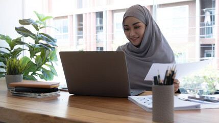 Portrait of Muslim Businesswoman Wearing Hijab Works on Project, Does Document Analysis. Empowered Digital Entrepreneur Works on e-Commerce Startup Project