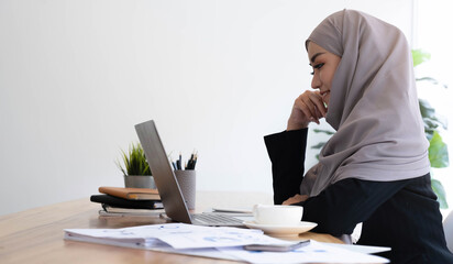 Young asian muslim business woman in smart casual wear discussing business and smiling while...