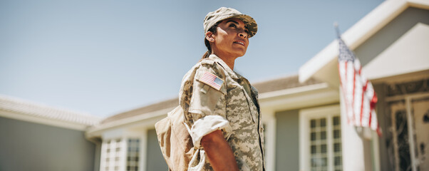 Courageous female soldier returning home from the army - obrazy, fototapety, plakaty