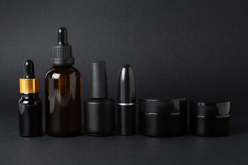 Set of black cosmetics on a black background