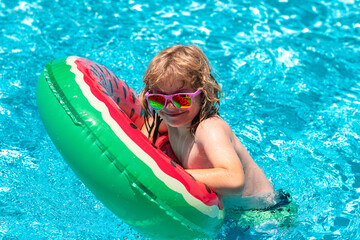Child water toys. Children play in tropical resort. Cute funny child boy relaxing with toy swimming...