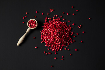 pile of pink peppercorns isolated on black background