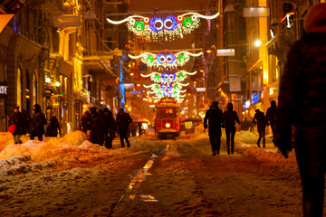Snowy day in Taksim, Beyoglu. Nostalgic tram in Istiklal Street. Taksim Istiklal Street is a...