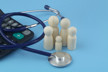 Price of medicine and insurance for family. Wooden people figures with calculator and stethoscope on blue.	