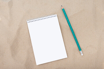 white paper and pencil on sandy background, layout, template