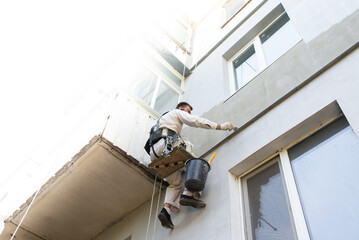builder climber repairs the facade of the building