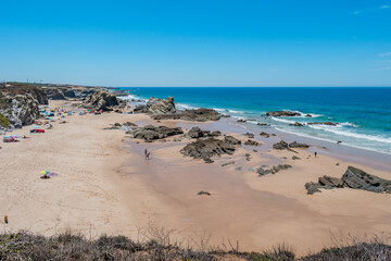 Fototapeta na wymiar Sand with rocks at low tide at Samoqueira beach, Porto Côvo PORTUGAL