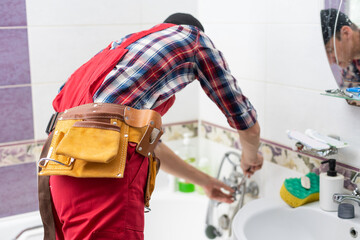 Fototapeta na wymiar plumber at work in a bathroom, plumbing repair service, assemble and install concept.
