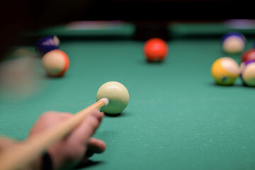a man plays billiards in a bar. snooker, man aiming at the cue ball