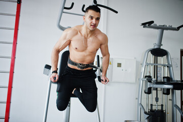 Fototapeta premium Muscular arab man training in modern gym. Fitness arabian men with naked torso doing exercises .