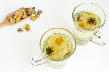 Chrysanthemum flower tea and 
dried chrysanthemum buds on white background. healthy beverage concept.