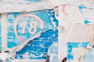 Torn and weathered street poster background with number 18 