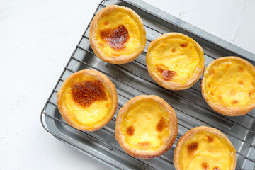 Closeup of Egg tart or portuguese egg tart. golden delicious new baked tart with egg on wooden table.