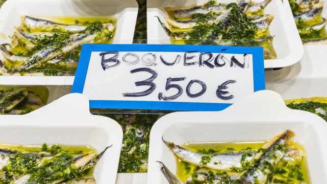 Boqueron marinated in vinegar and olive oil with chopped parsley, Spanish gastronomy, on the sign translated into English means price of anchovy.