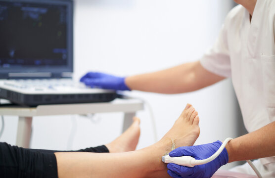a physiotherapist performing an ultrasound on the ankle to check for injury
