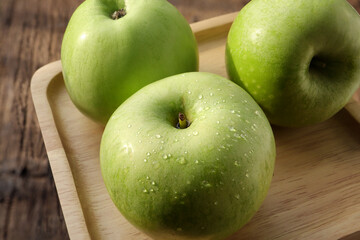 Green apples. Fresh ripe green apple on wooden plate.