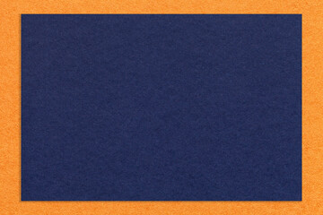 Texture of craft navy blue color paper background with orange border, macro. Structure of ultramarine cardboard