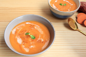 Homemade sweet potato soup served with sour cream in bowl on the table. vegetarian food. 