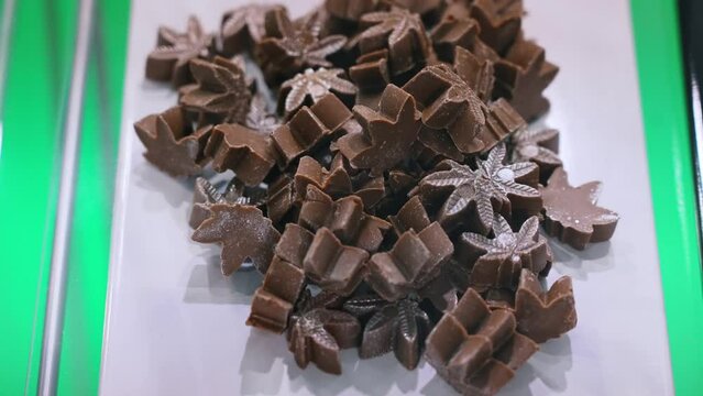 Cannabis CBD CBG. Chocolate brown weed cookies in the shape of marijuana leaves. Alternative cooking. High quality 4k footage