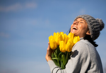person holding a bouquet of yellow tulips