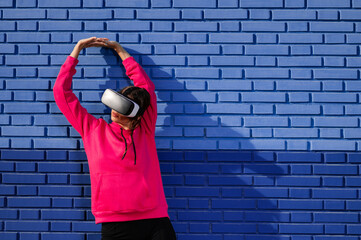 Caucasian woman using a virtual reality glasses on a background of blue bricks