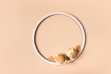 Autumn composition. Wooden ring and dried flowers on pastel beige background. Autumn, fall concept. Flat lay, top view, copy space.