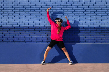 Caucasian woman using a virtual reality glasses on a background of blue bricks