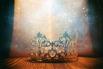 low key image of beautiful queen or king crown in front of old book. vintage filtered. fantasy medieval period