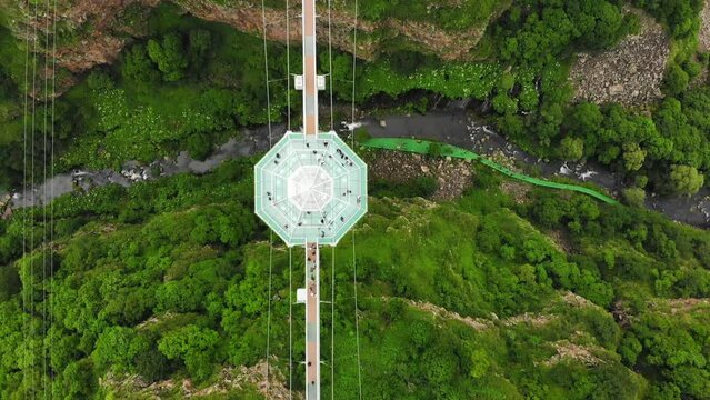 Dashbashi, Georgia - 19th june, 2022: Aerial fly over Diamond shape platform on glass bridge over scenic dashbashi valley in Georgia countryside. Famous modern bridge over valley in caucasus