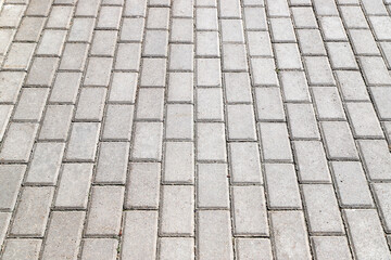 Sidewalk paved with gray tiles in perspective. Photo with selective focus