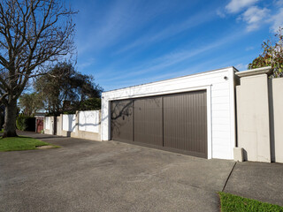 Fototapeta na wymiar Garage with wooden roller door painted dark brown. Copy space stock photo.