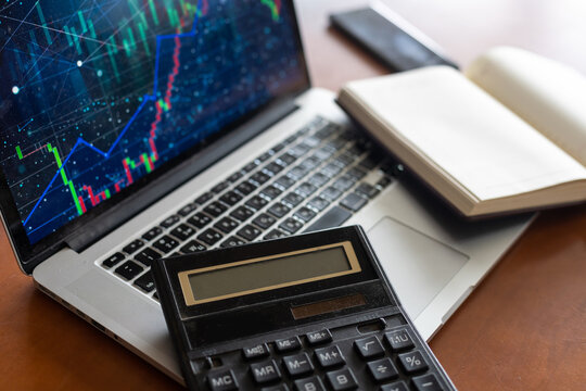 The report summarizes the results of business operations,laptop computer, calculator on desk of investor. top view.