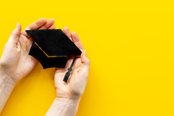 Hands holding graduation hat or academic cap paper cut. Education concept