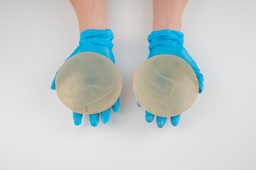 Doctor plastic surgeon demonstrates different breast implants. 