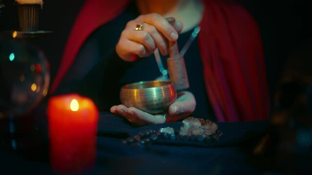 Black witch whispering spells and entering trance to the sounds of singing bowl