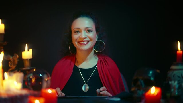 Friendly woman fortune-teller smiling, seeing good news on clients tarot layout